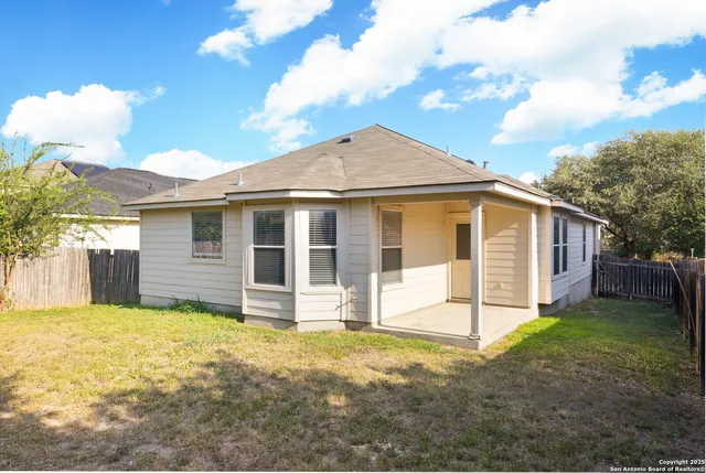 a view of a house with backyard and a tree