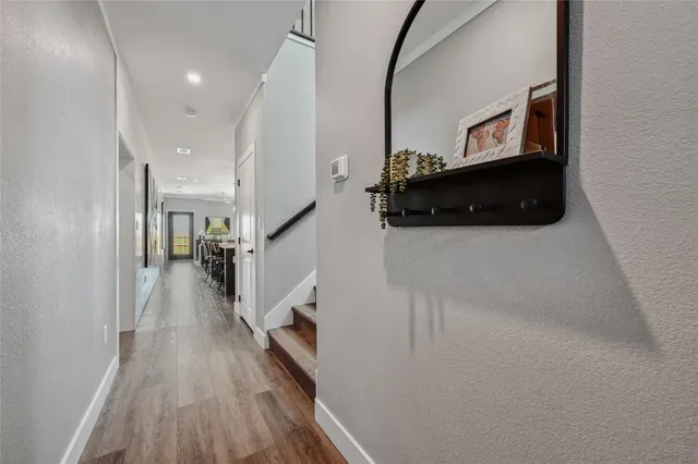 a view of a hallway with wooden floor and staircase