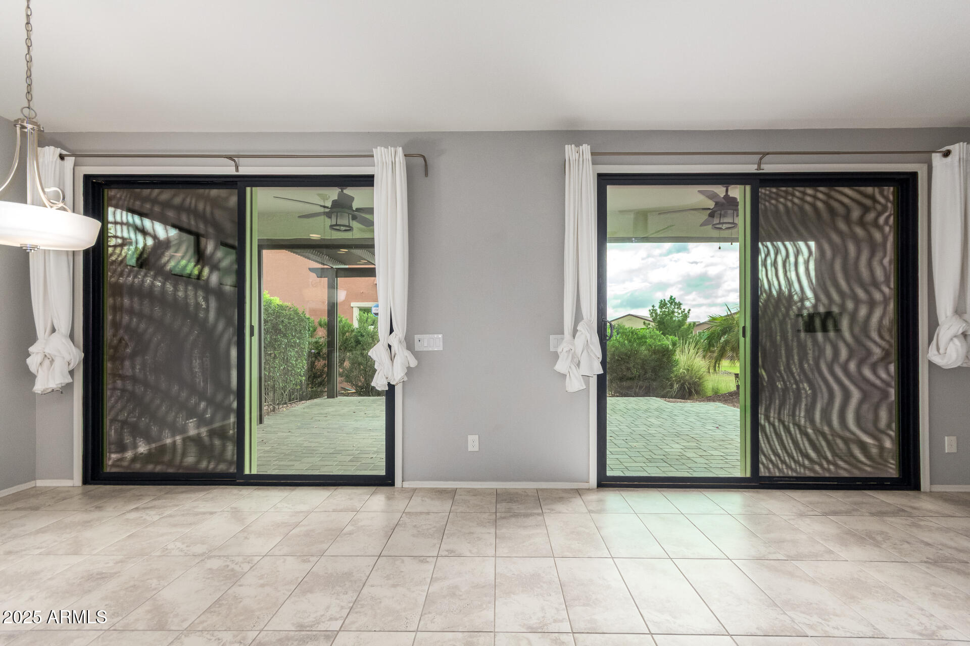 41609 West Summer Wind Way Maricopa, AZ 85138 - Photo 3 of 40 an empty room with sliding glass door and glass door