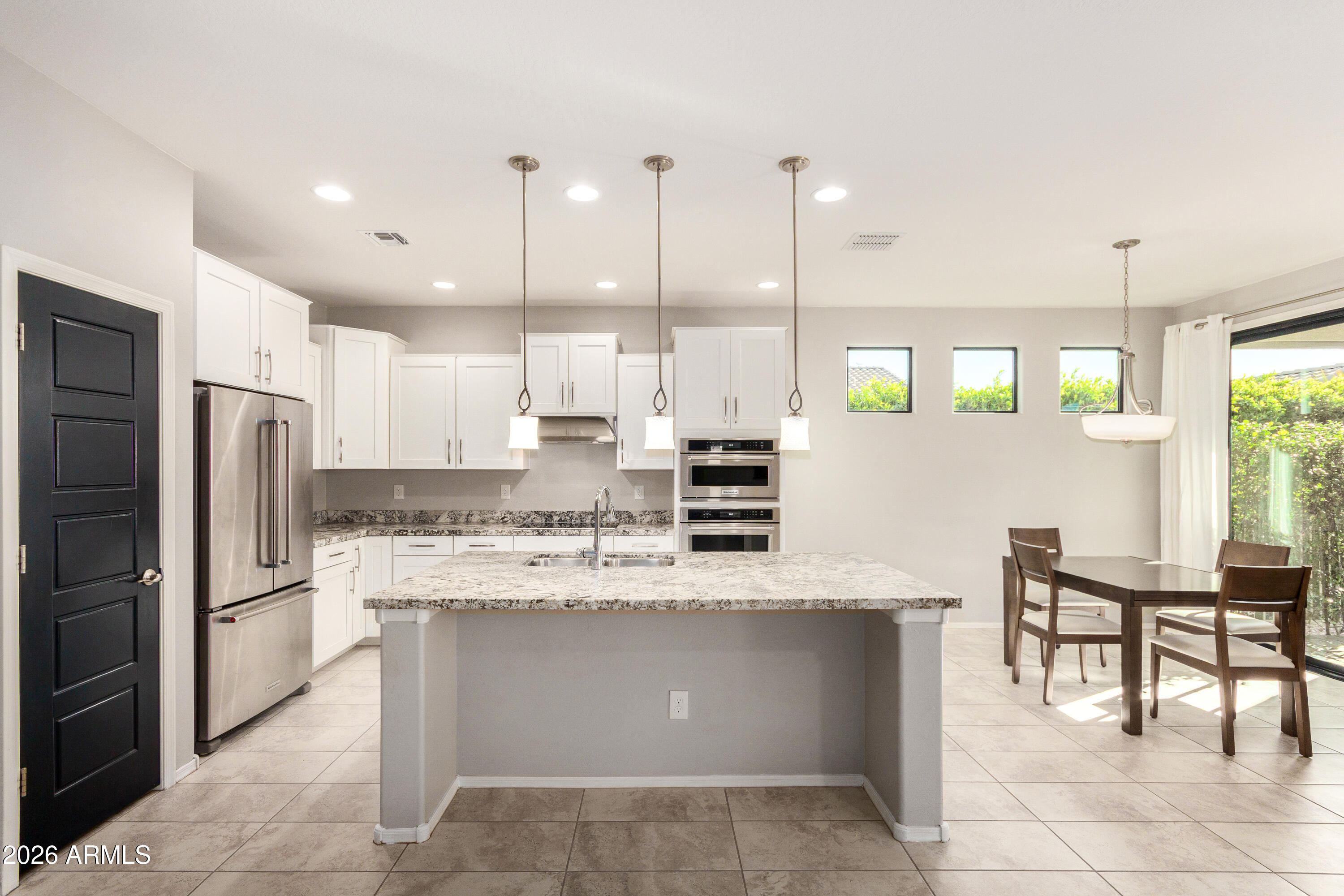41609 West Summer Wind Way Maricopa, AZ 85138 - Photo 4 of 40 a large kitchen with a large counter top appliances and cabinets