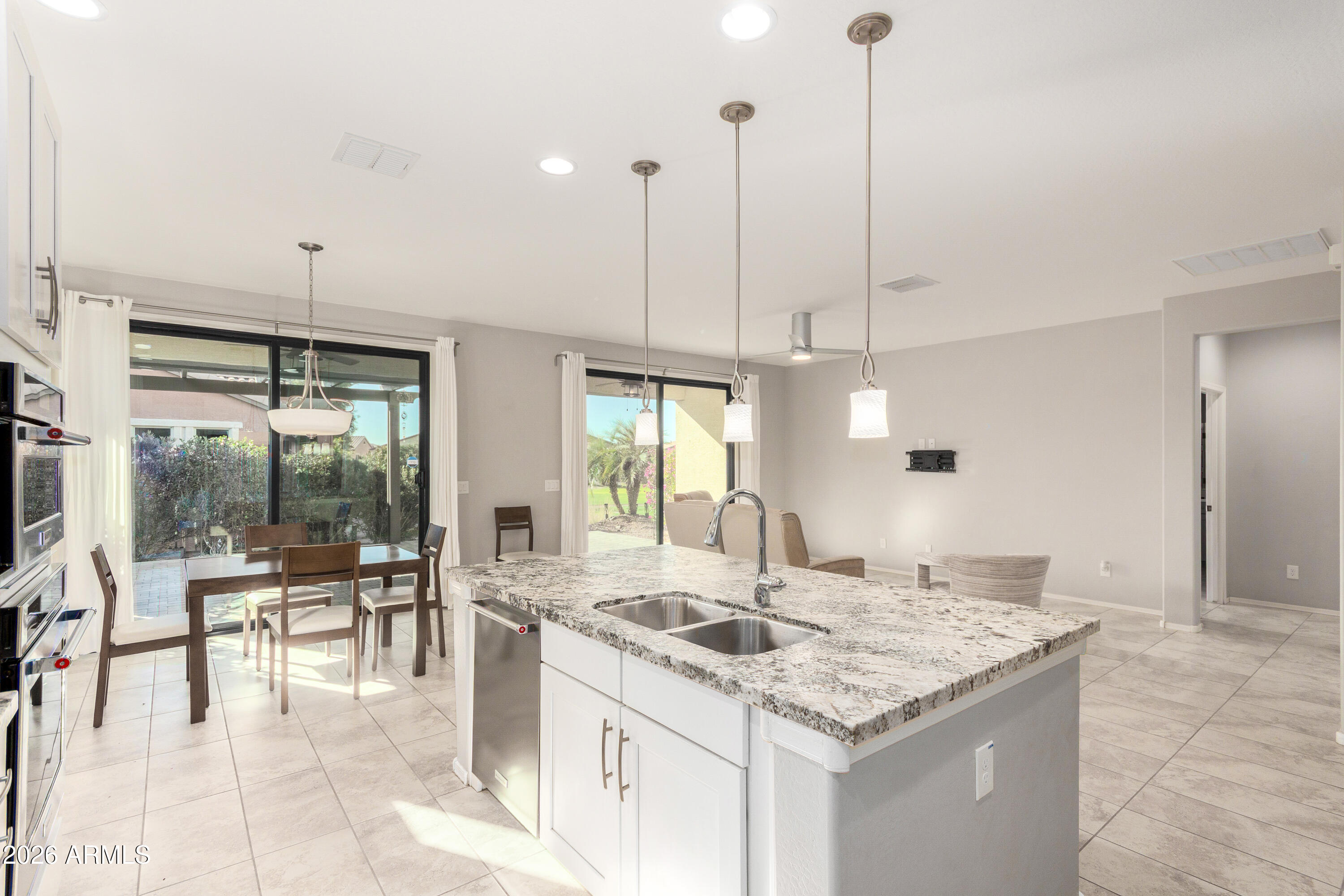 41609 West Summer Wind Way Maricopa, AZ 85138 - Photo 5 of 40 a kitchen with granite countertop a sink a counter top space and living room view