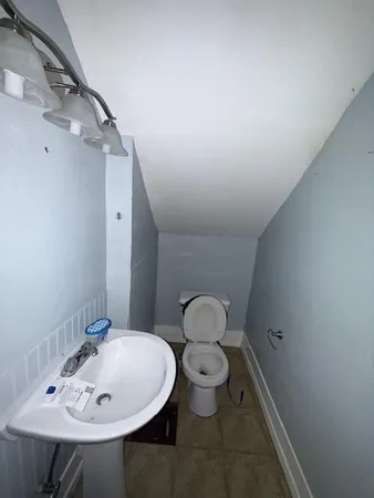 a bathroom with a sink a toilet and a mirror