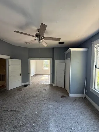 a view of a livingroom with a ceiling fan and window