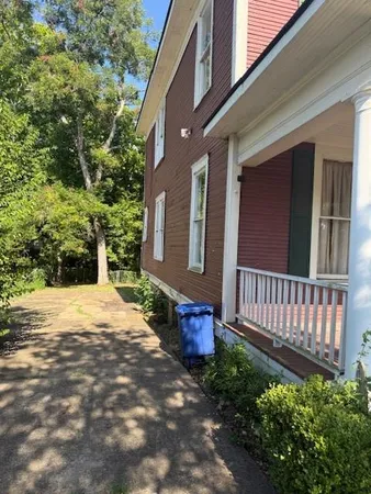 a pathway of a house with a yard