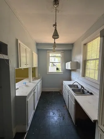 a kitchen that has a sink stainless steel appliances a window and a counter top space