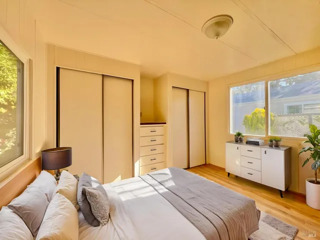 a bedroom with a bed dresser and a large window