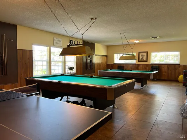 a front view of a house with garden and trees