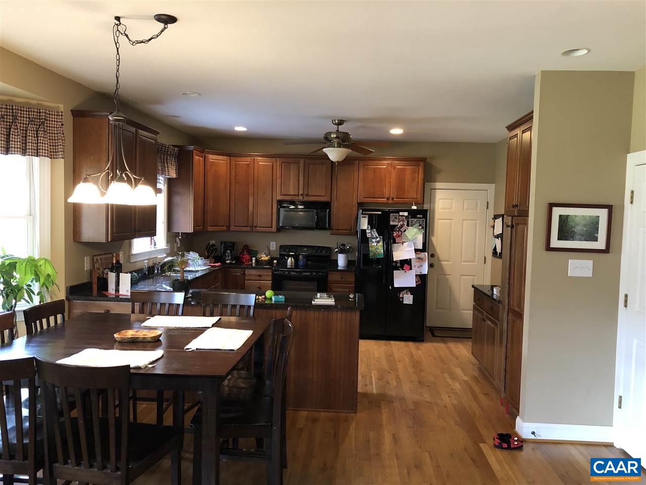 3285 Hardware River Road Charlottesville, VA 22903 - Photo 13 of 22 a kitchen with stainless steel appliances kitchen island granite countertop a refrigerator a stove a sink a dining table and chairs with wooden floor