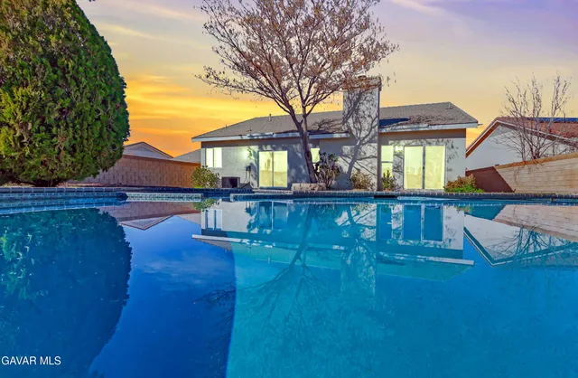 a view of a house with backyard and sitting area