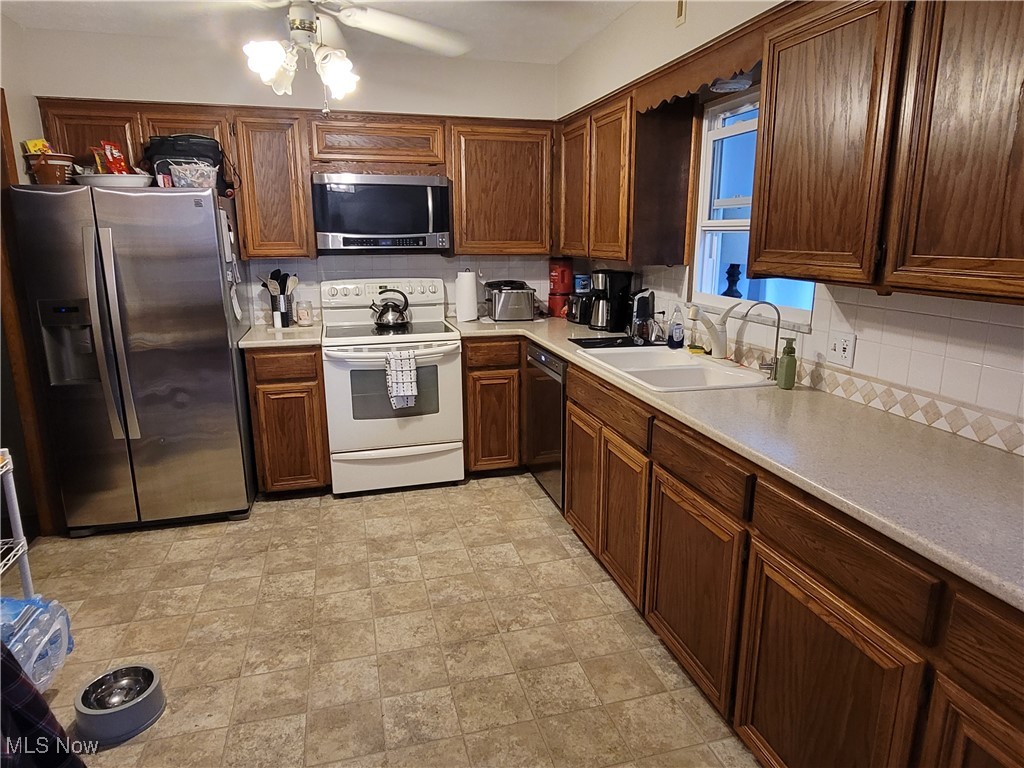2768 Greenridge Road Barberton, OH 44203 - Photo 4 of 14 Kitchen featuring stainless steel appliances, backsplash, ceiling fan, and sink