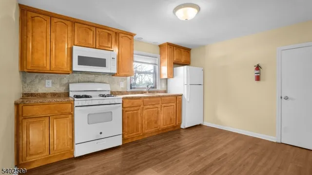 a kitchen with a sink cabinets stainless steel appliances and wooden floor