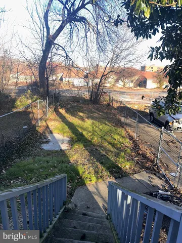 a view of a yard with wooden fence