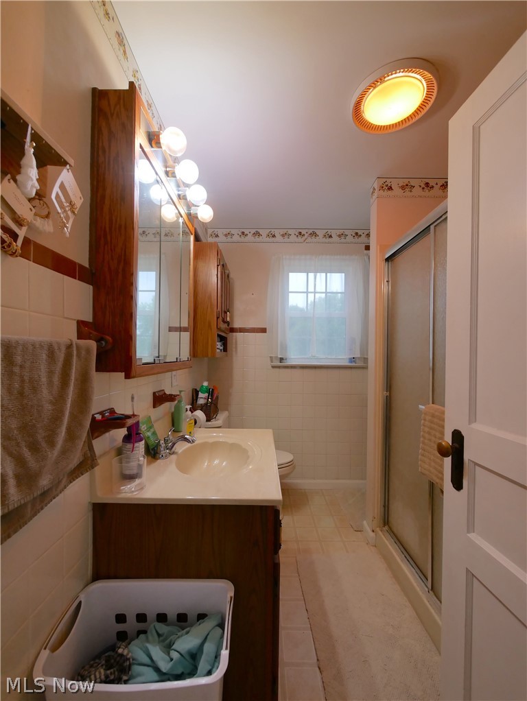 72622 Colerain Road Dillonvale, OH 43917 - Photo 9 of 17 Vanity with a single basin sink, wall-mounted lighting, built-in medicine cabinet, and a shower enclosure with a sliding door