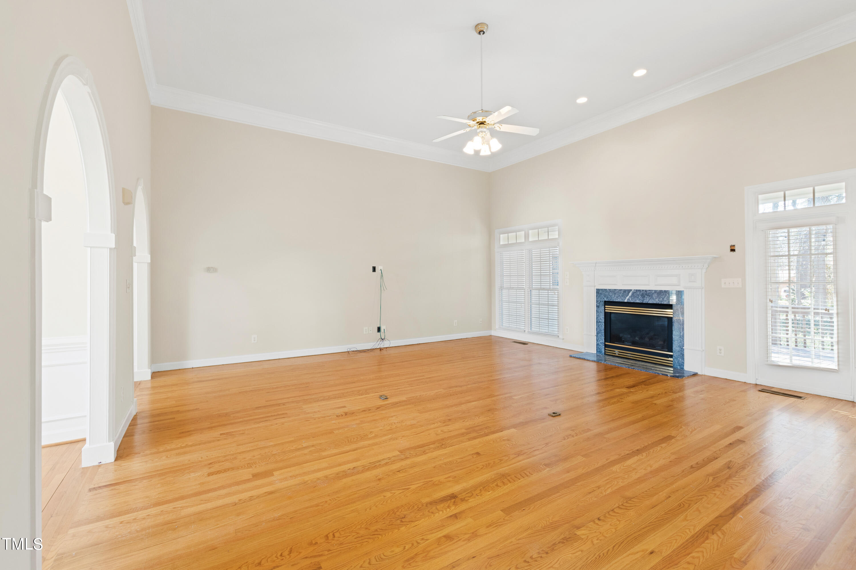 7637 Wilderness Road Raleigh, NC 27613 - Photo 11 of 33 an empty room with wooden floor and fireplace