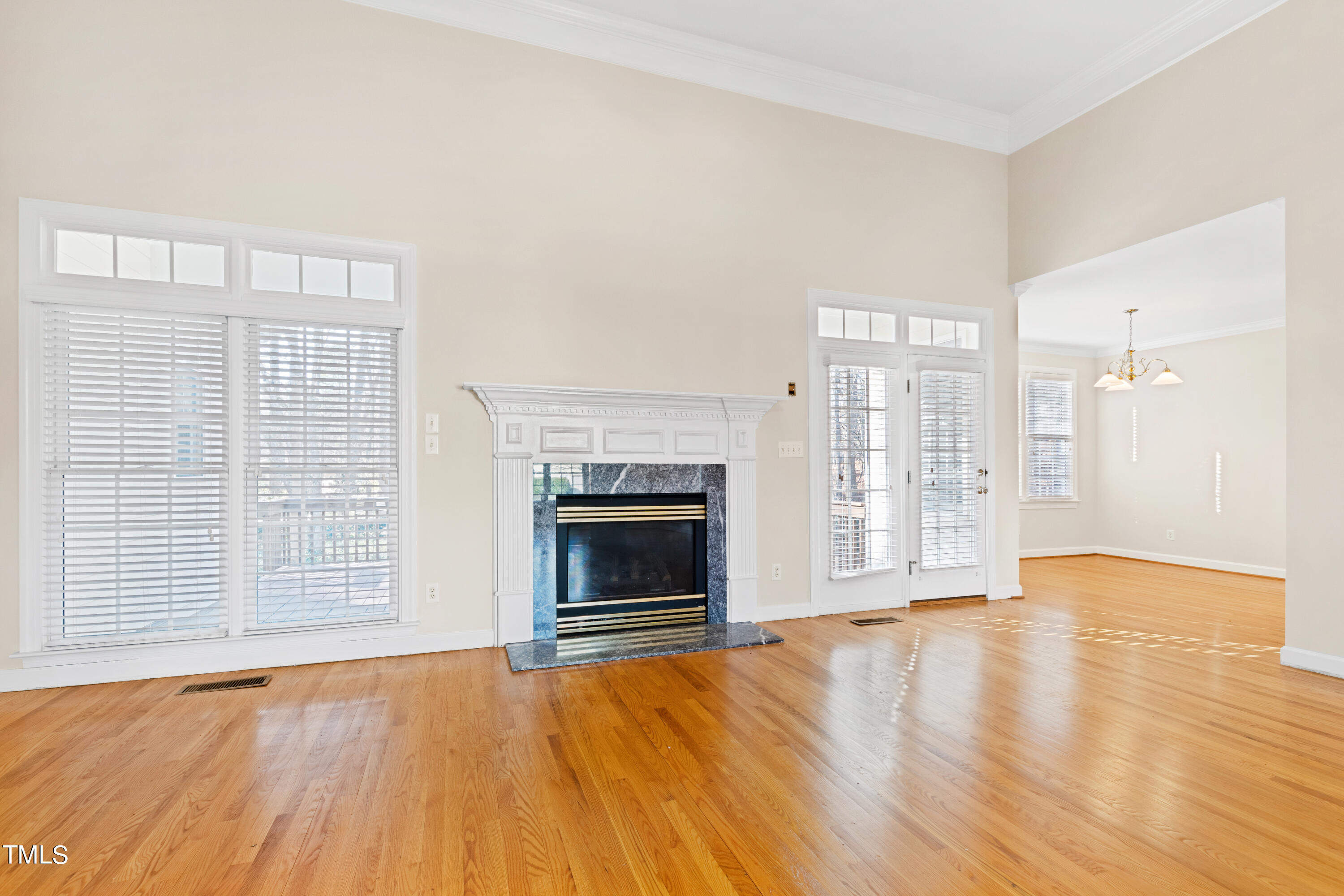 7637 Wilderness Road Raleigh, NC 27613 - Photo 12 of 33 a view of an empty room with wooden floor fireplace and a window