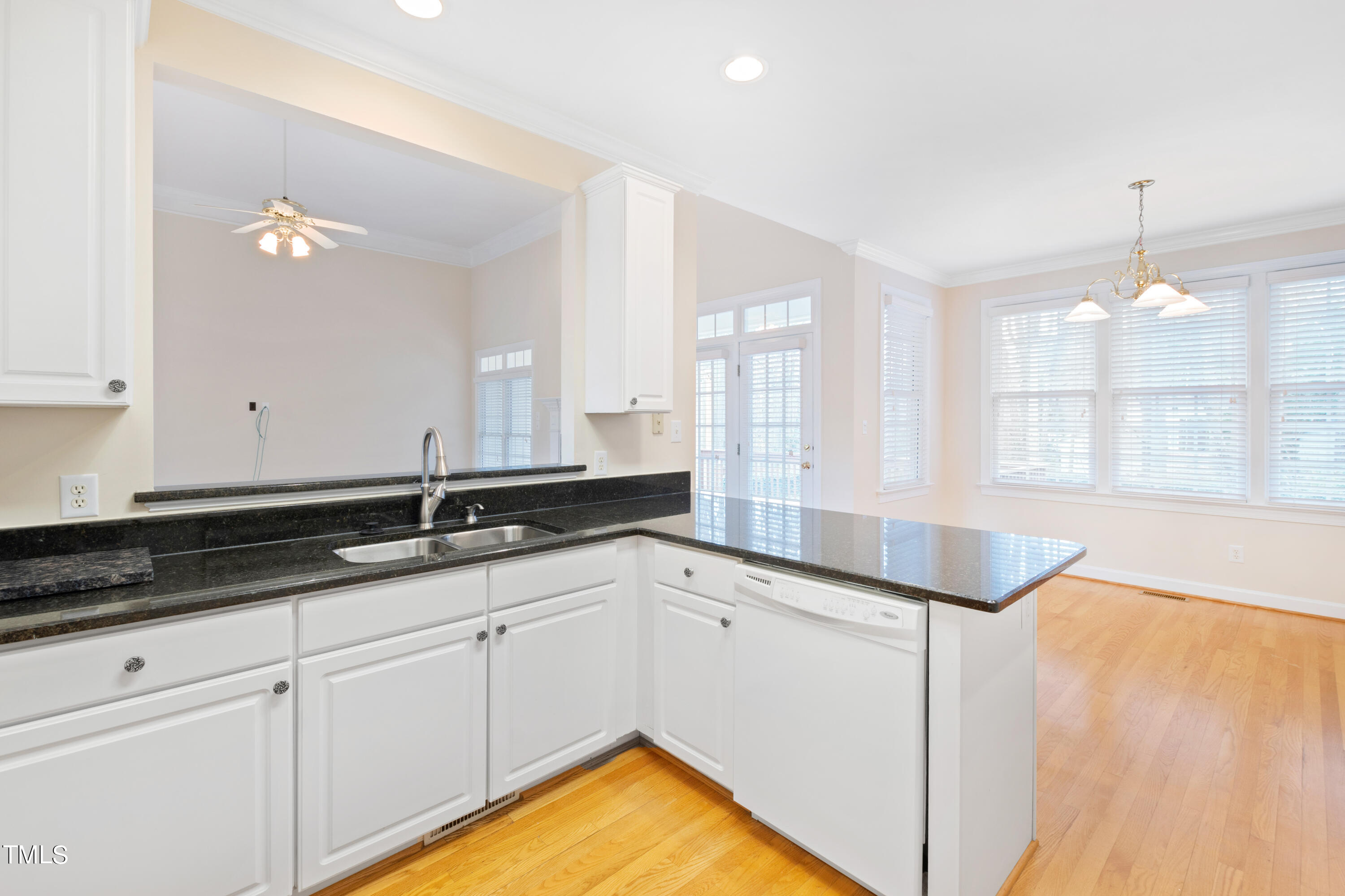 7637 Wilderness Road Raleigh, NC 27613 - Photo 14 of 33 a kitchen with granite countertop a sink and white cabinets