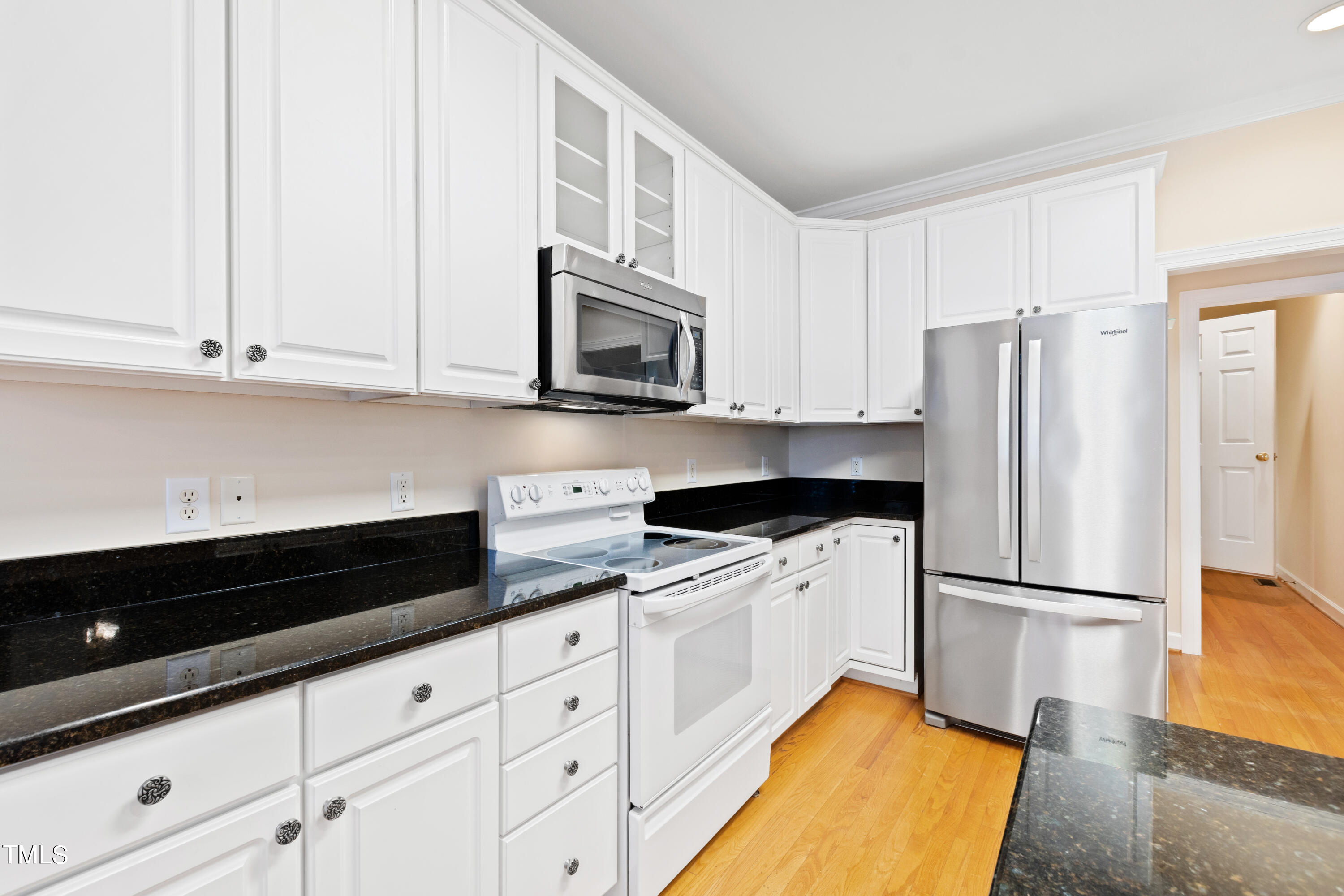 7637 Wilderness Road Raleigh, NC 27613 - Photo 16 of 33 a kitchen with granite countertop white cabinets and stainless steel appliances