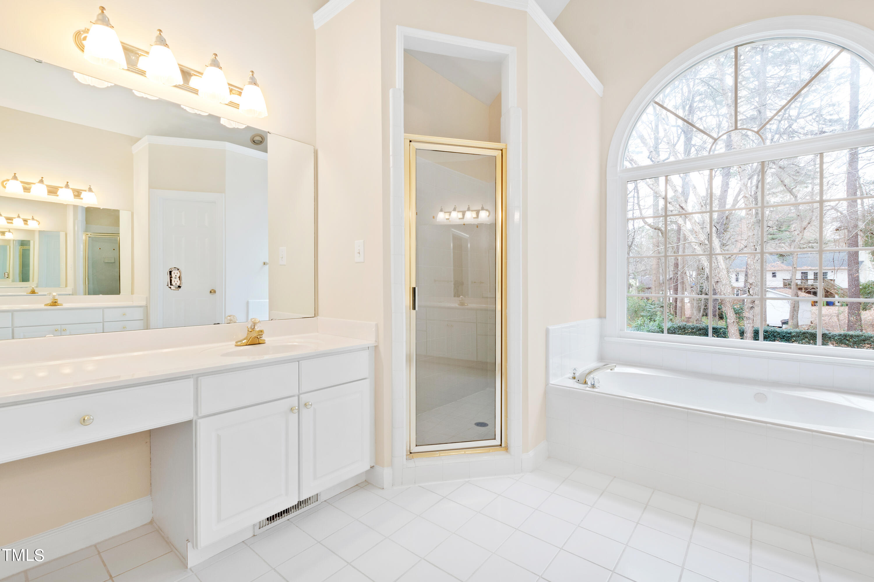 7637 Wilderness Road Raleigh, NC 27613 - Photo 19 of 33 a spacious bathroom with a tub sink and mirror