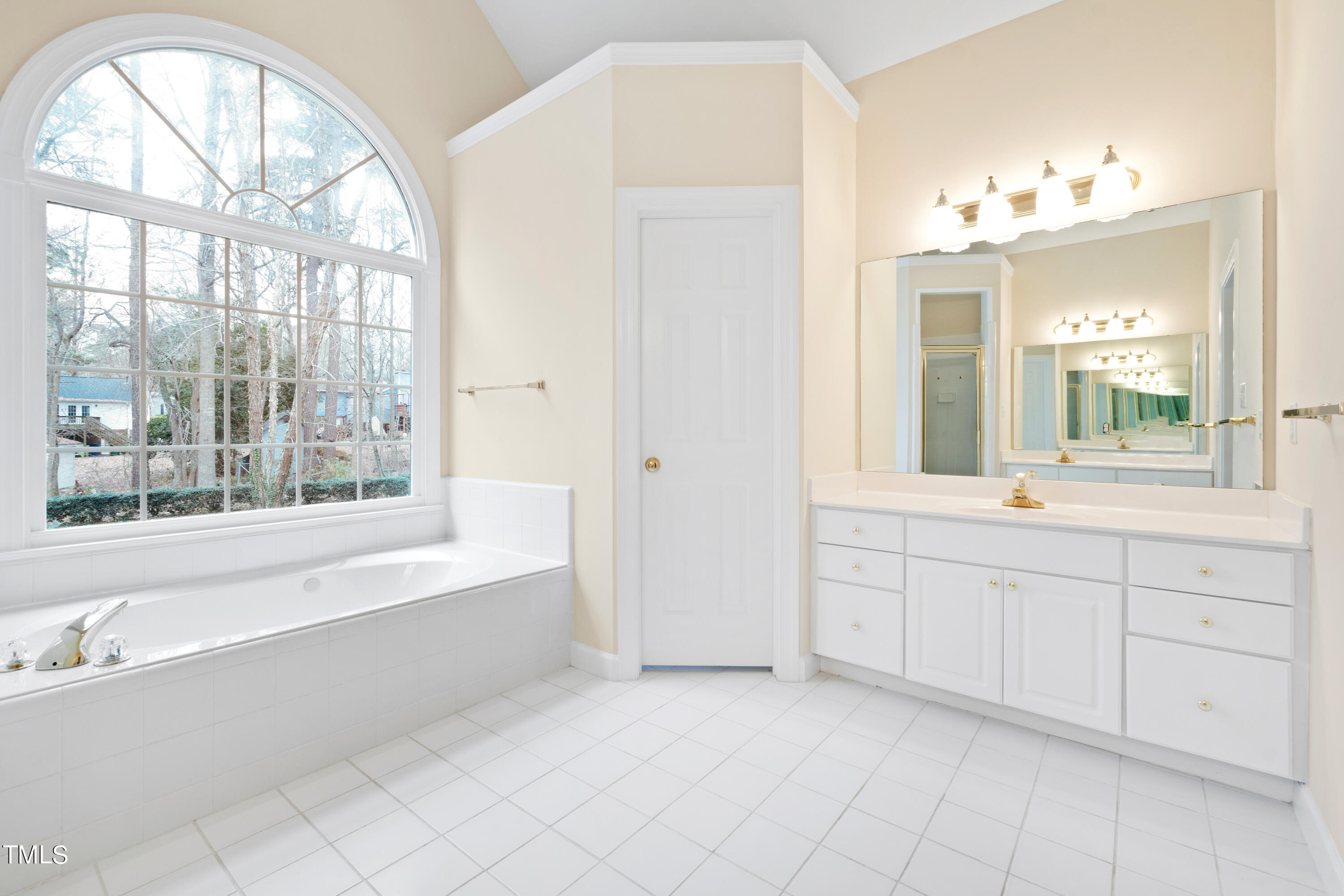 7637 Wilderness Road Raleigh, NC 27613 - Photo 20 of 33 a spacious bathroom with a mirror a bathtub and a shower