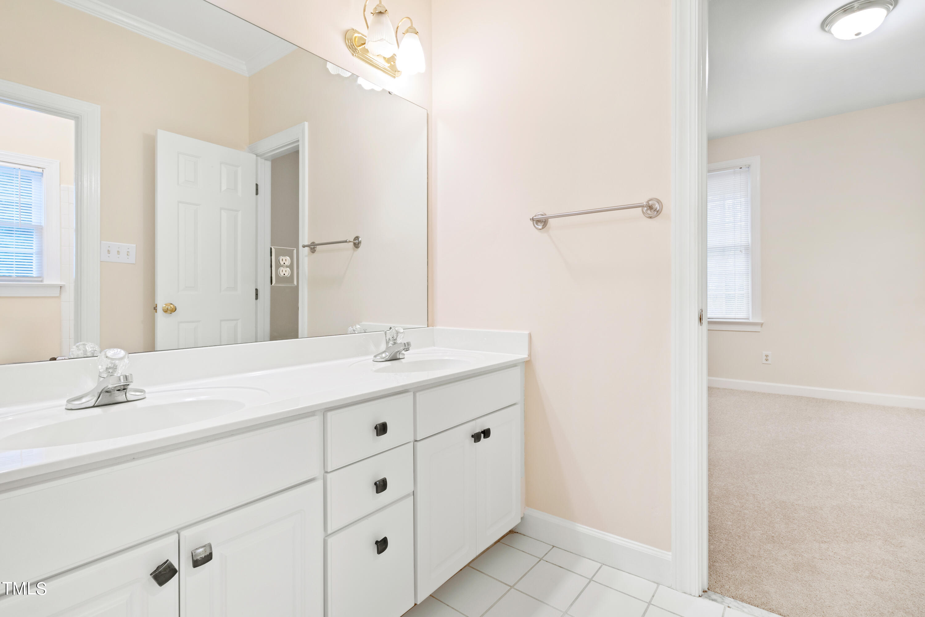 7637 Wilderness Road Raleigh, NC 27613 - Photo 23 of 33 a bathroom with a double vanity sink and mirror