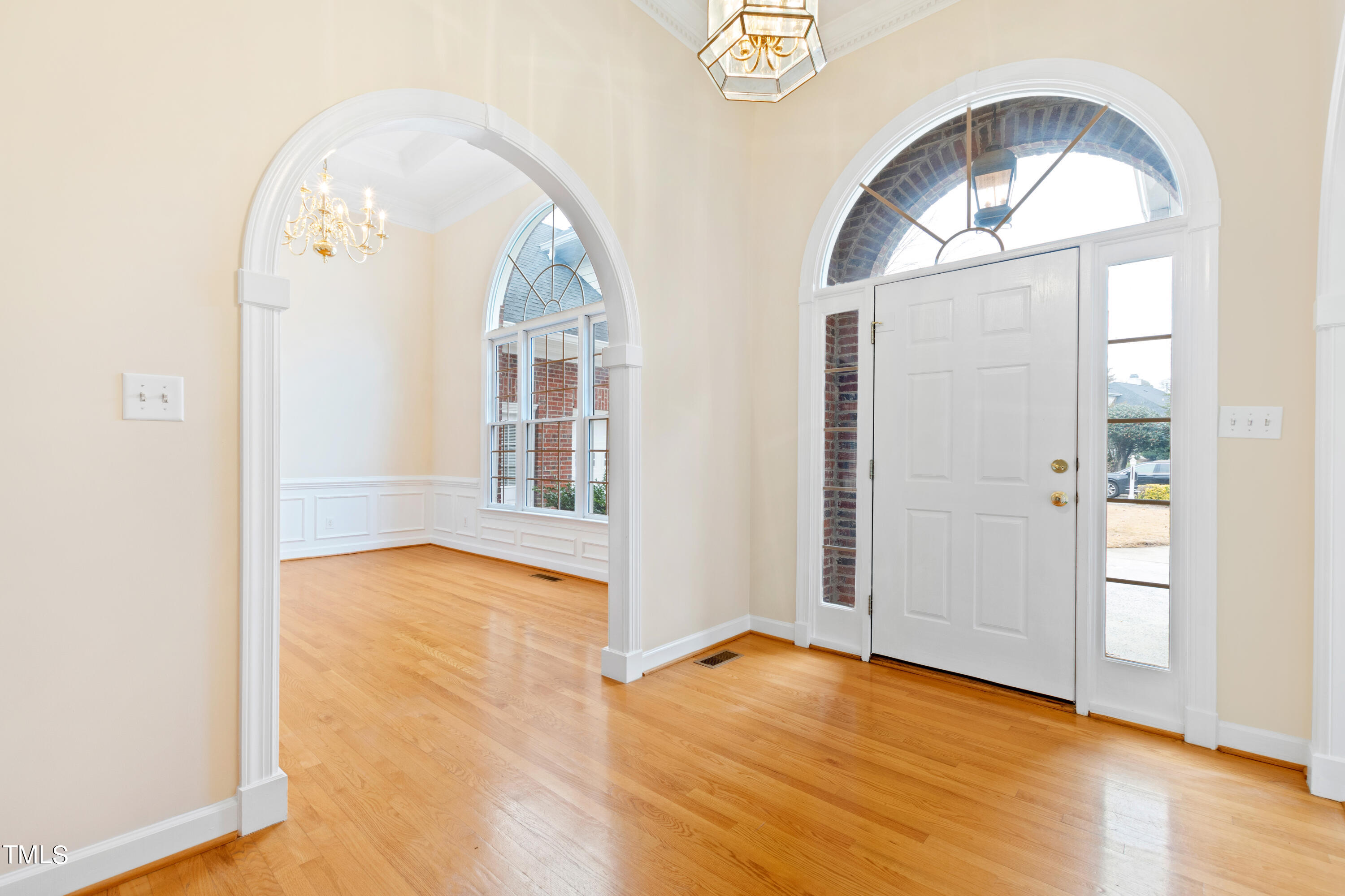 7637 Wilderness Road Raleigh, NC 27613 - Photo 4 of 33 an empty room with wooden floor mirror and windows