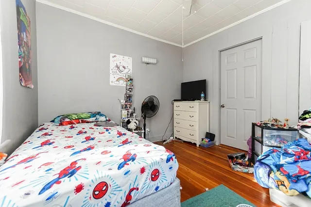 a bedroom with a bed and a tv on the dresser