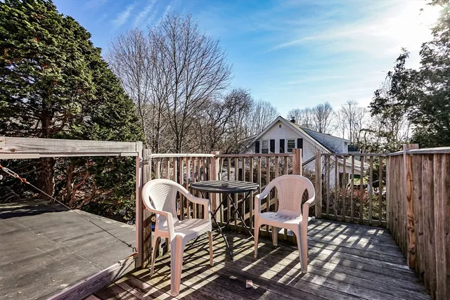 a roof deck with table and chairs and wooden floor