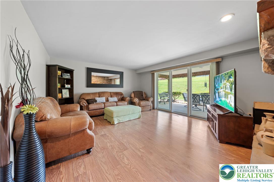 947 Tamenend Road Bath, PA 18014 - Photo 4 of 61 Hardwood flooring extends throughout this generous living room, offering direct access to an outdoor patio and green space.