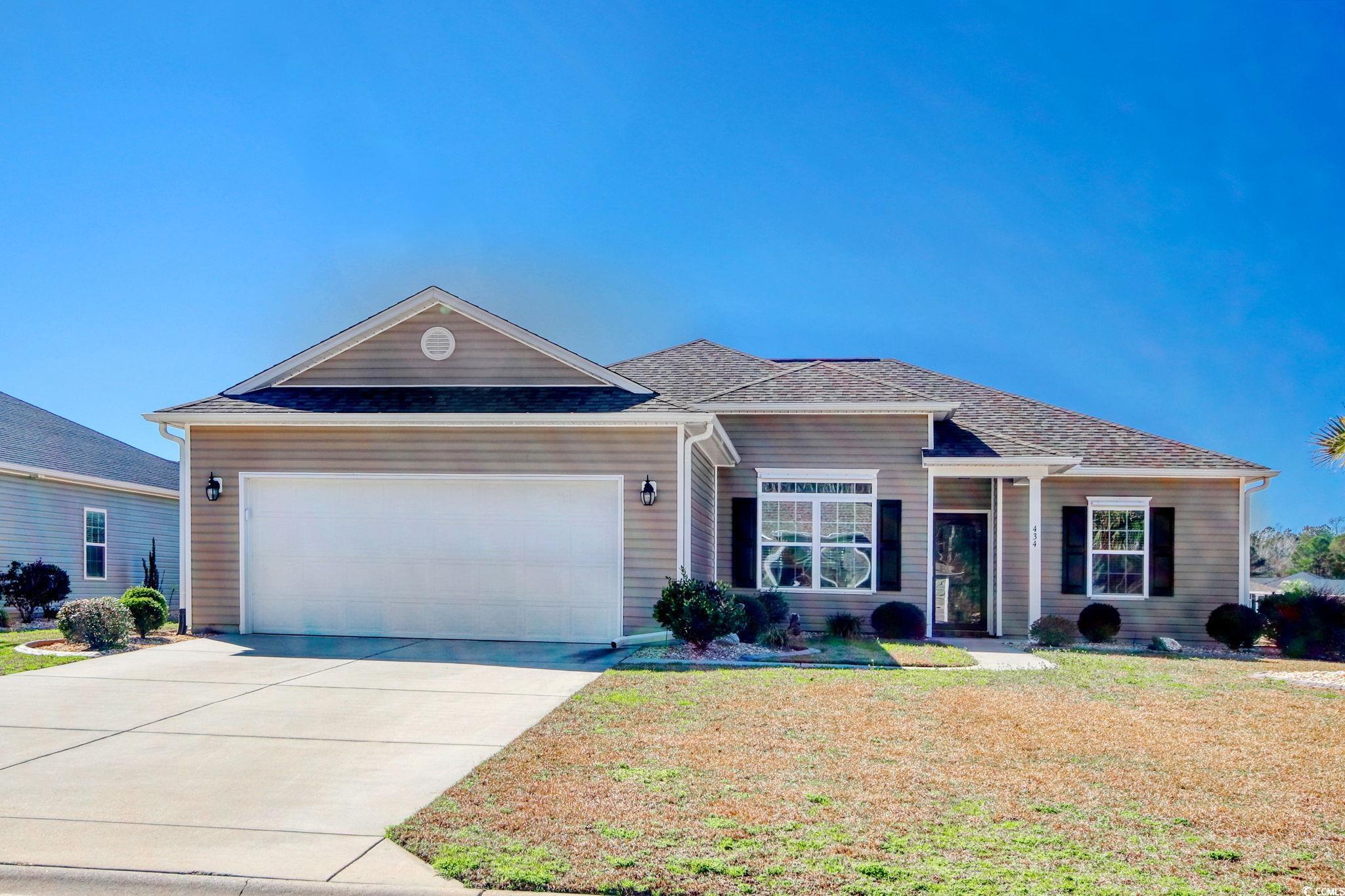 Ranch-style home featuring a front lawn and a gara