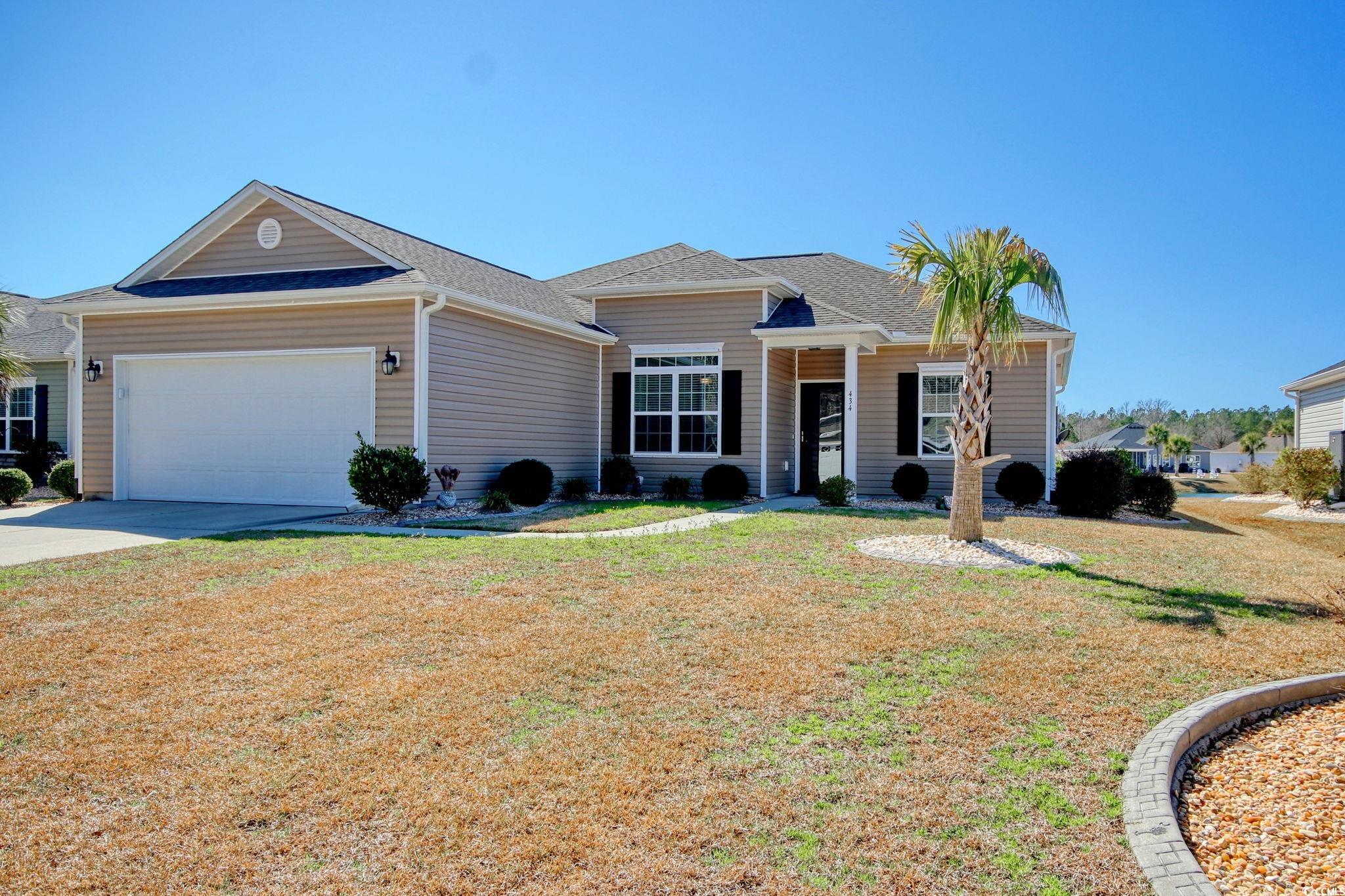 Ranch-style home with a front yard and a garage