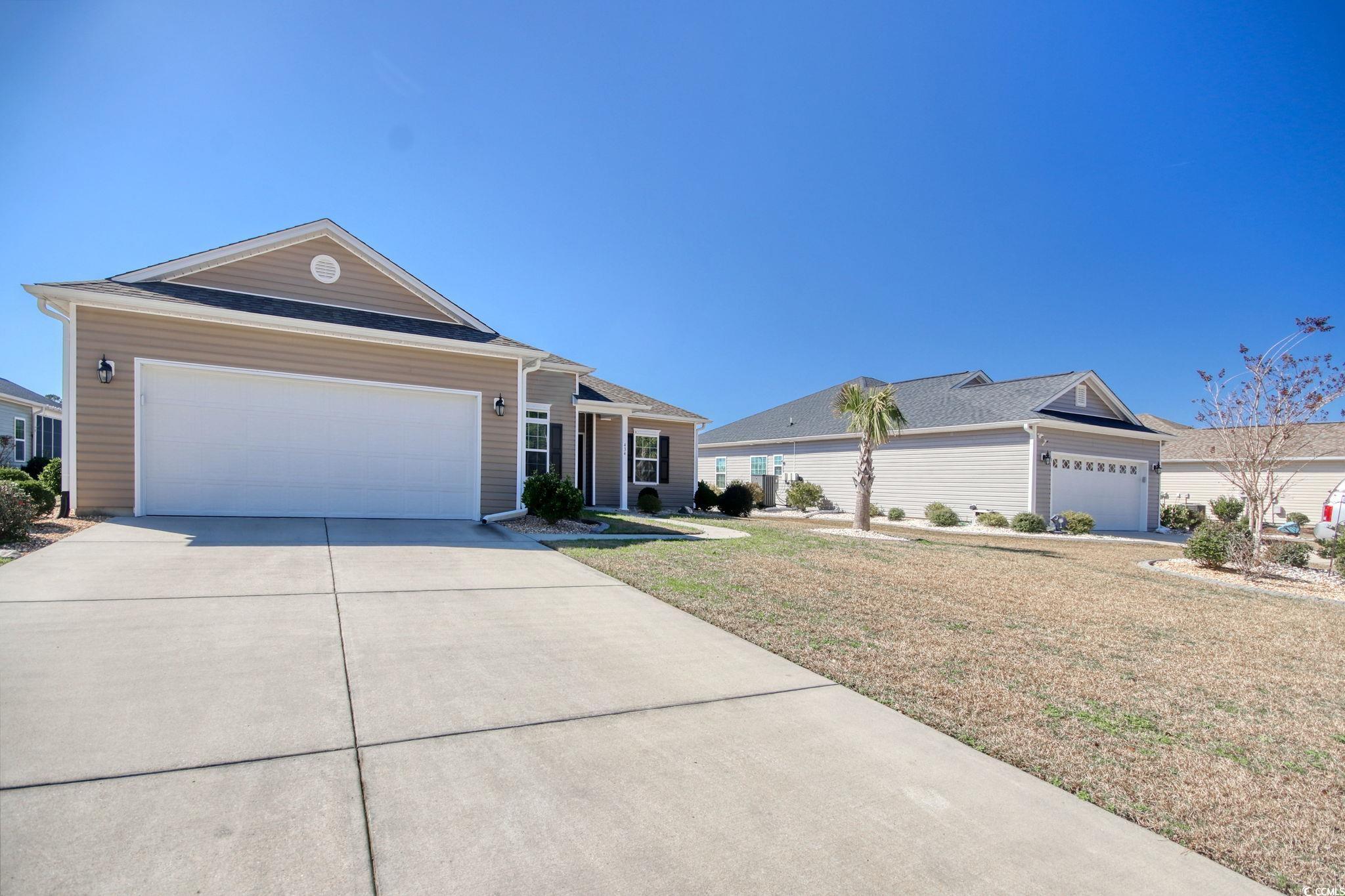 Ranch-style home with a front yard and a garage