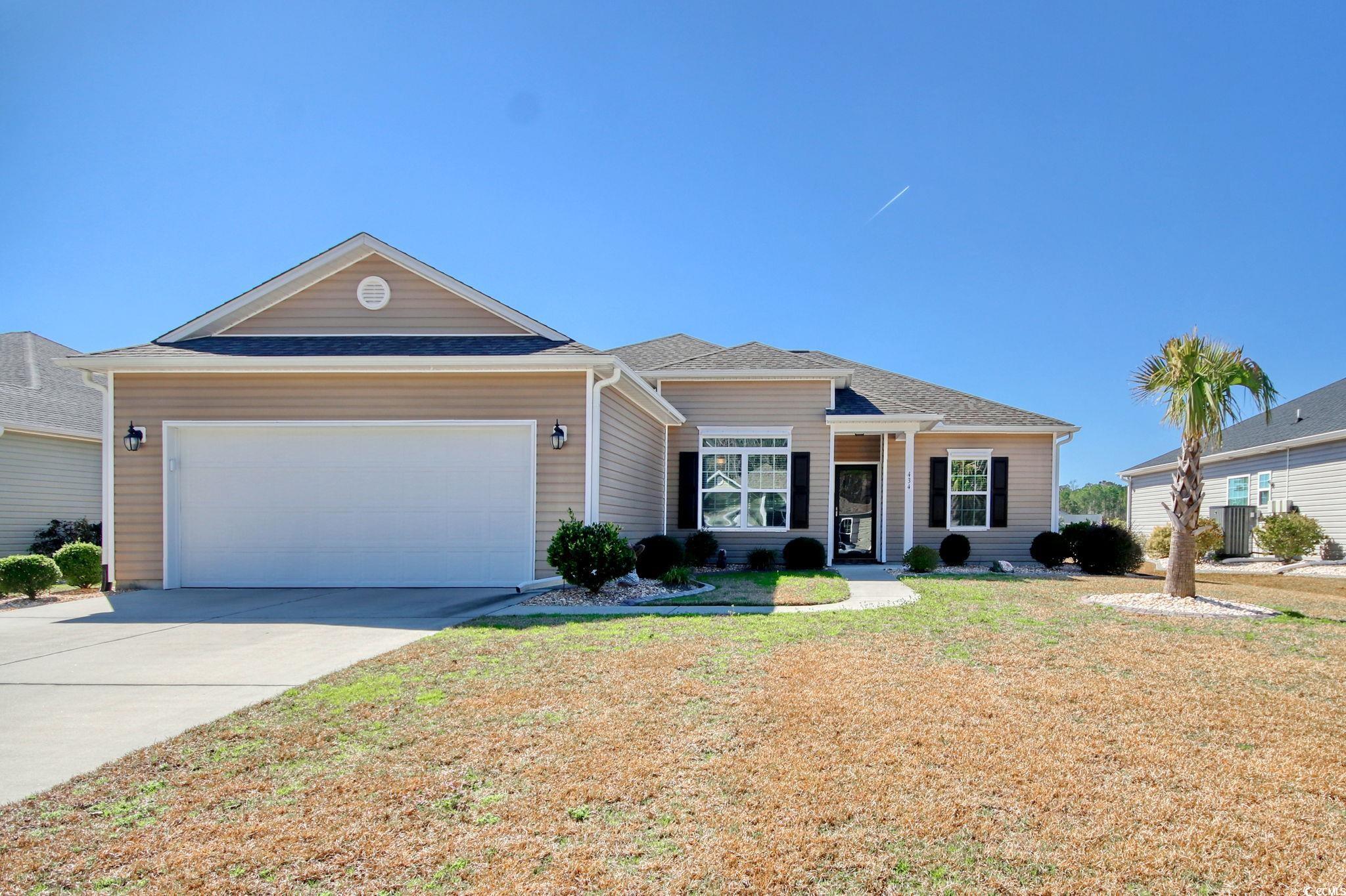 Ranch-style home featuring a garage and a front ya