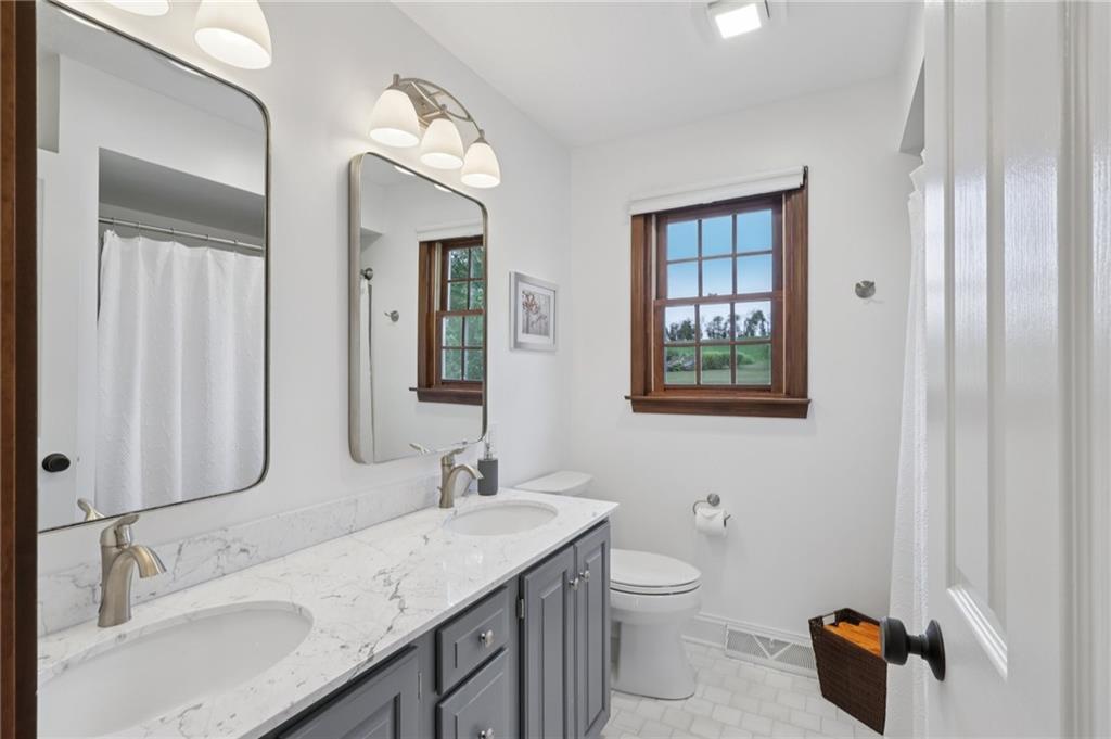111 American School Road Harmony, PA 16037 - Photo 23 of 46 a bathroom with a granite countertop sink a toilet and a mirror