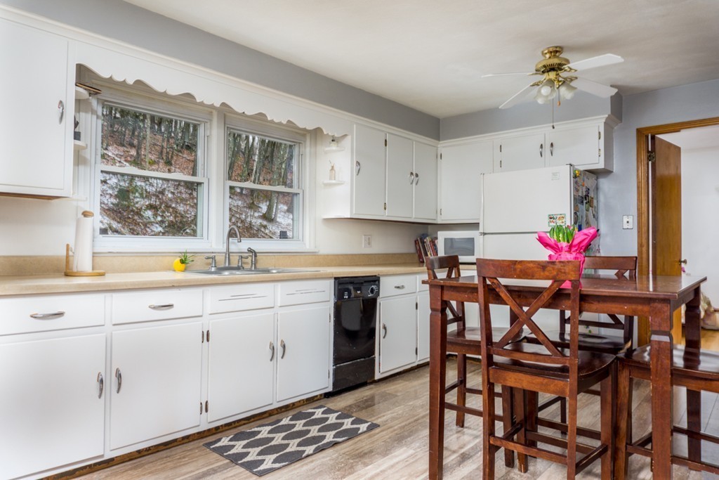 2032 Calkins Road Palmer, MA 01069 - Photo 2 of 23 a kitchen with a dining table chairs and white cabinets
