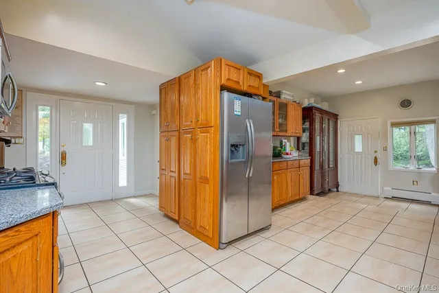 a view of a refrigerator in kitchen and an empty room