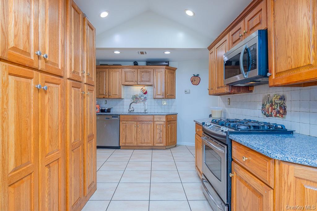 23 Sky Meadow Road Suffern, NY 10901 - Photo 6 of 36 a kitchen with stainless steel appliances granite countertop a stove a sink and a microwave
