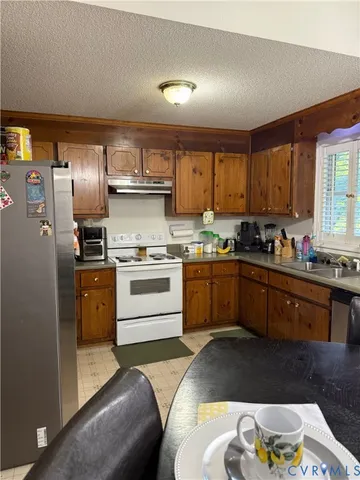 a kitchen with granite countertop a sink stainless steel appliances and cabinets