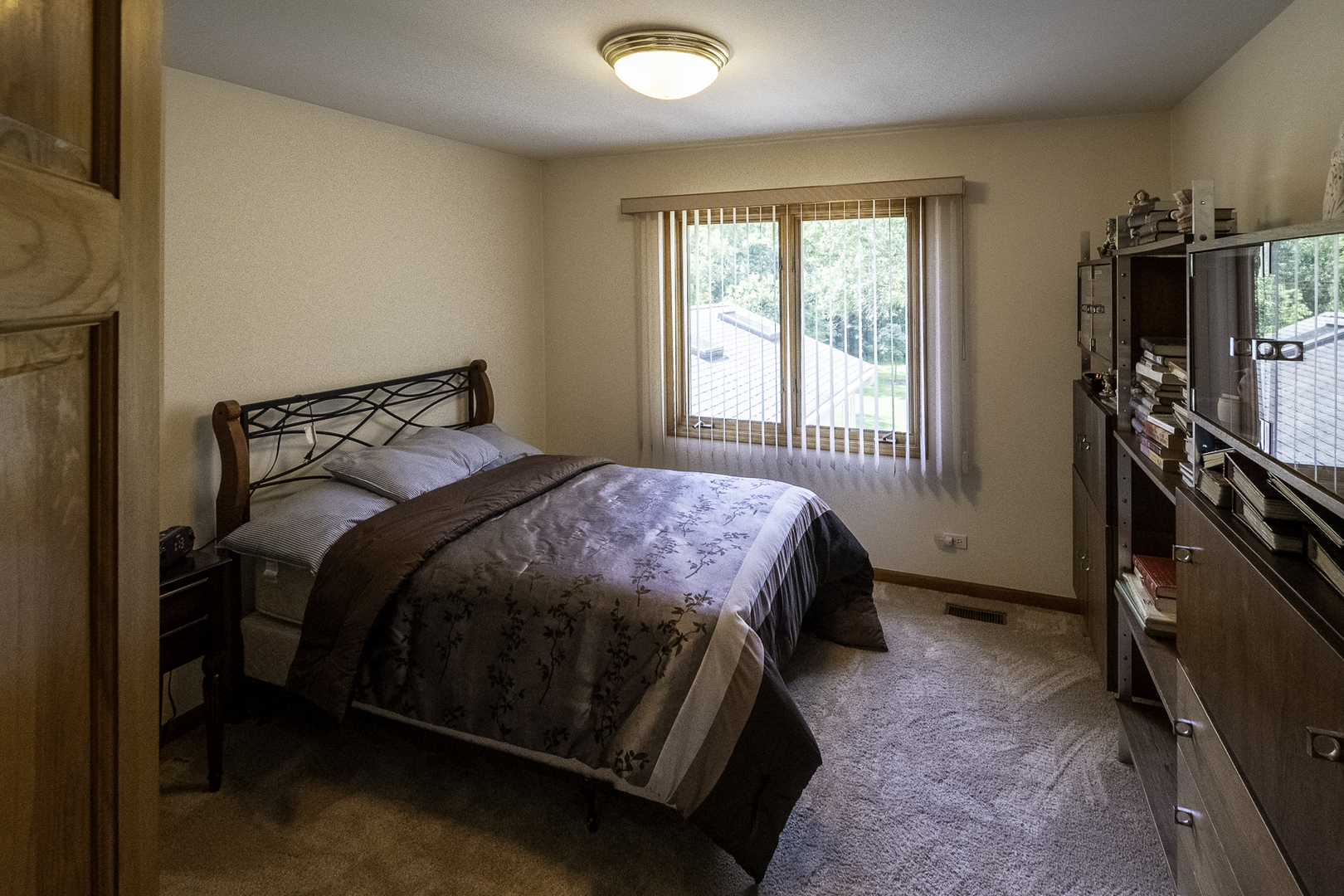 4214 Venard Road Downers Grove, IL 60515 - Photo 34 of 45 a bedroom with a bed and a flat tv screen on the dresser