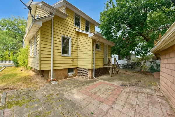 a backyard of a house with table and chairs