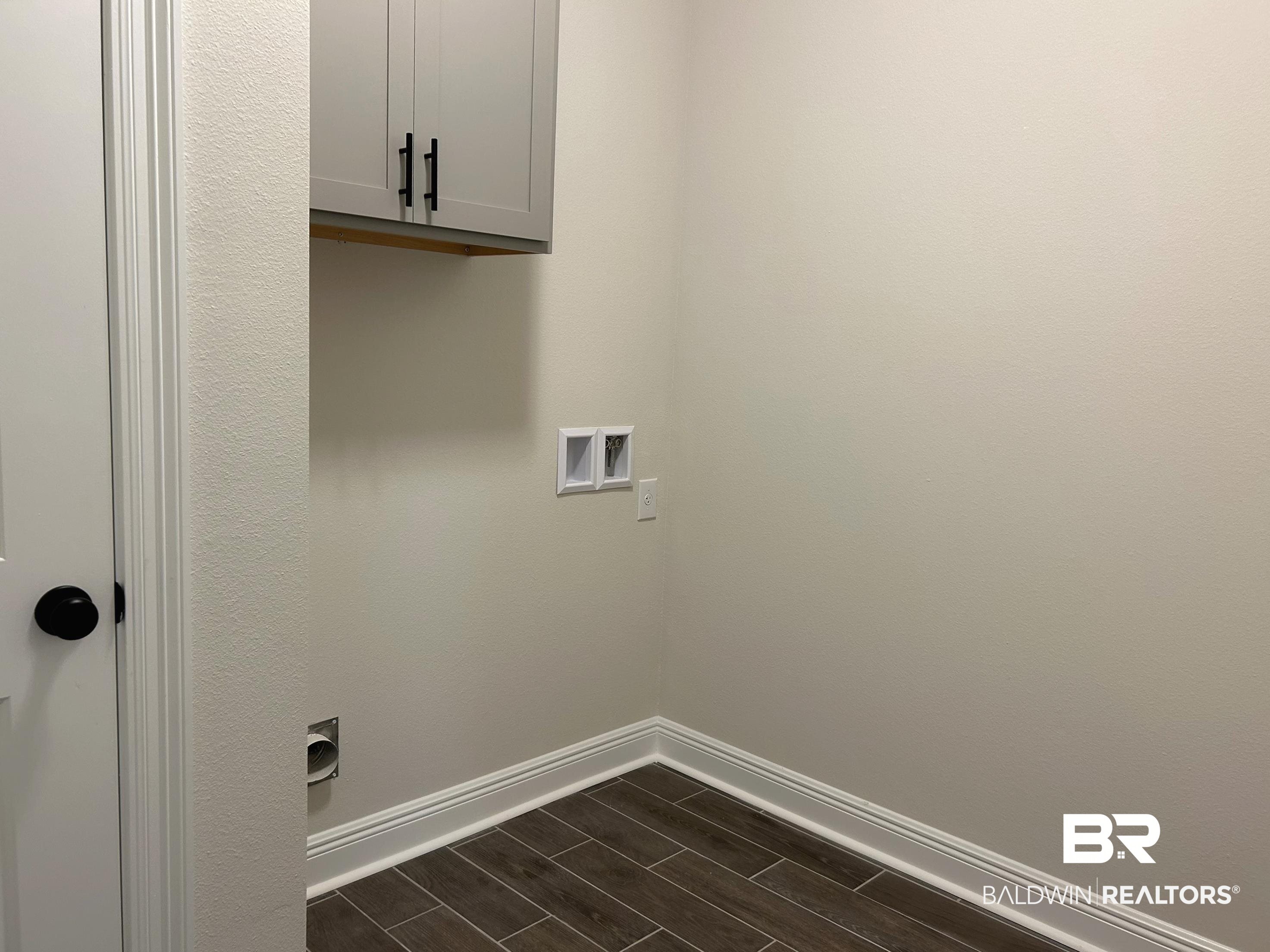 844 Sumter Loop Foley, AL 36535 - Photo 16 of 18 Laundry room with hookup for a washing machine, dark hardwood / wood-style floors, and cabinets