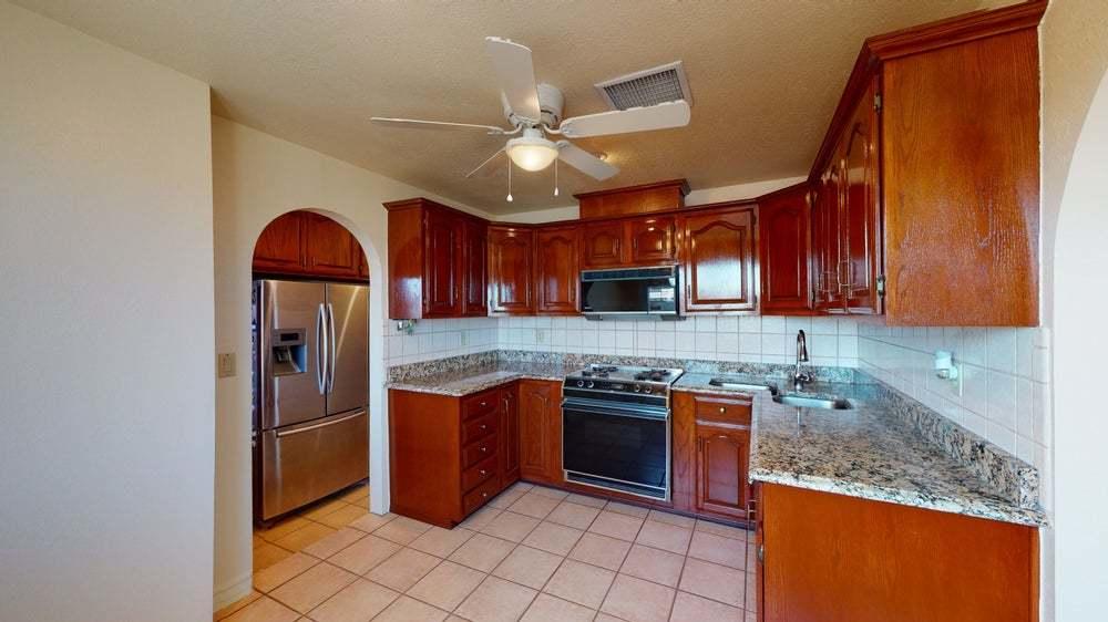 a kitchen with stainless steel appliances granite countertop a stove refrigerator sink and microwave