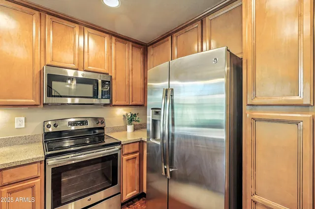 a kitchen with a refrigerator a stove a microwave and cabinets