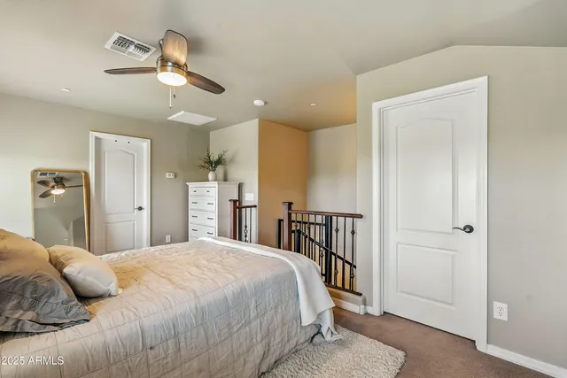 a bedroom with a large bed and ceiling fan