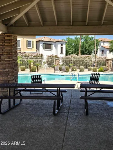 a sitting area with chairs and table in front of a building