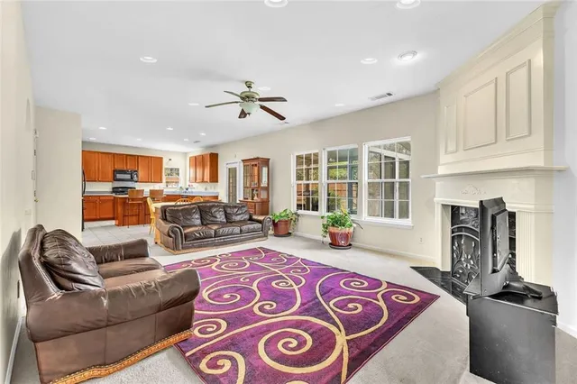 a kitchen with stainless steel appliances granite countertop a refrigerator a sink a stove a dining table and chairs with wooden floor