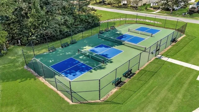 a view of a house with a big yard and large trees