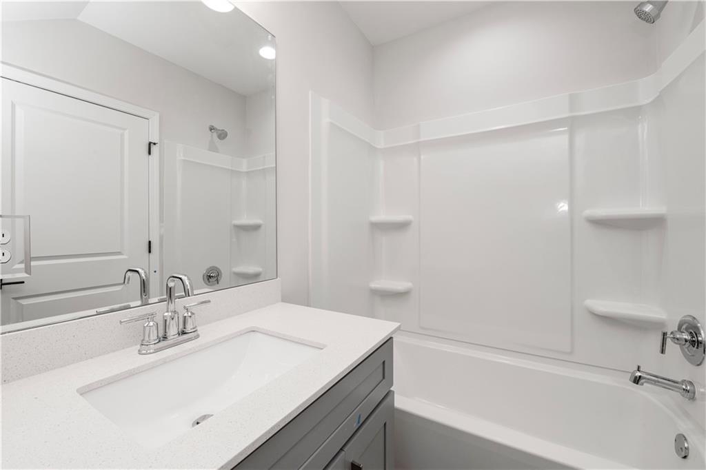 2010 Main Street Northwest Atlanta, GA 30318 - Photo 29 of 37 a bathroom with a sink a bathtub and a mirror