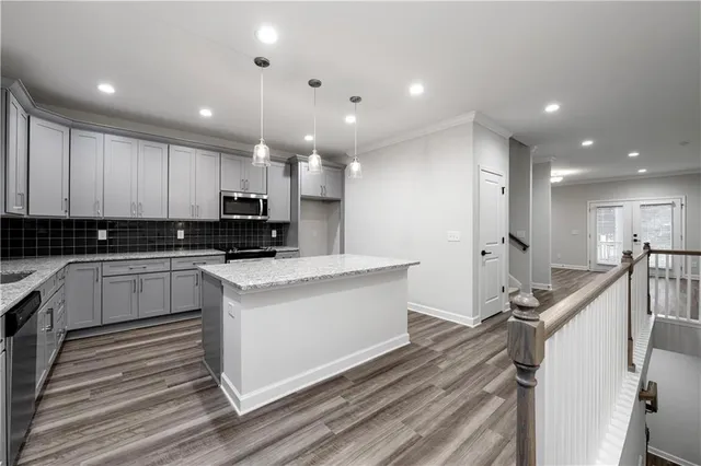 a view of kitchen with granite countertop stainless steel appliances sink stove microwave and cabinets