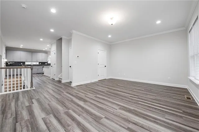 an empty room with wooden floor and window