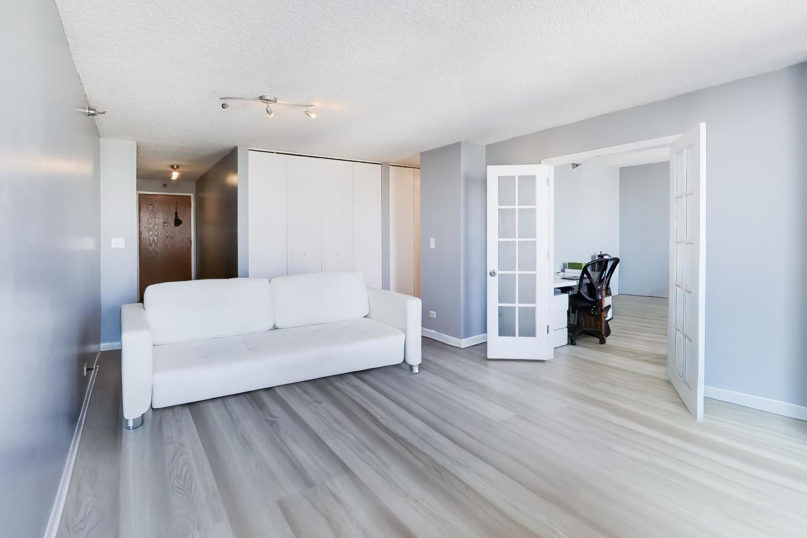 1122 North Clark Street, Unit 3705 Chicago, IL 60610 - Photo 11 of 38 a living room with furniture and a wooden floor
